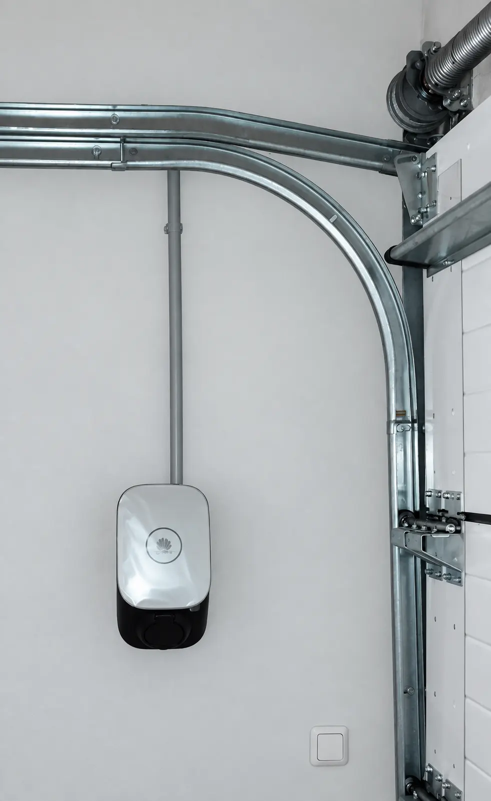 Wallbox neben einem Garagentor mit fest verlegter Zuleitung – E-PN Kundenprojekt