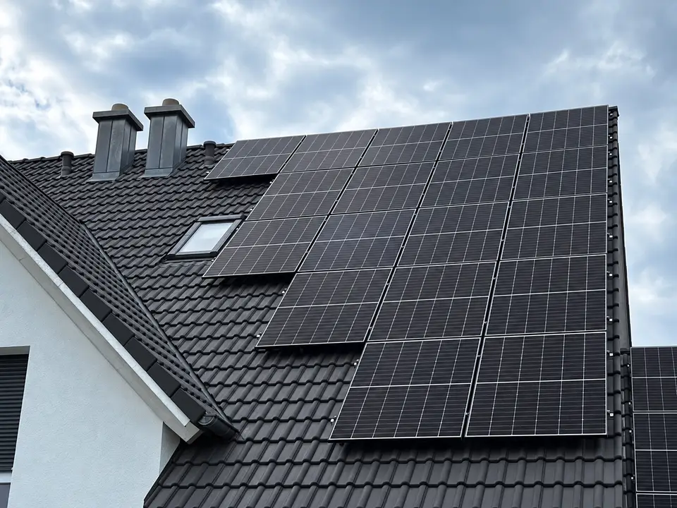 Fertig montierte Photovoltaikanlage auf einem schwarzen Ziegeldach