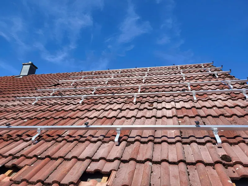 Montageschienen auf dem Ziegeldach während der Photovoltaikmontage